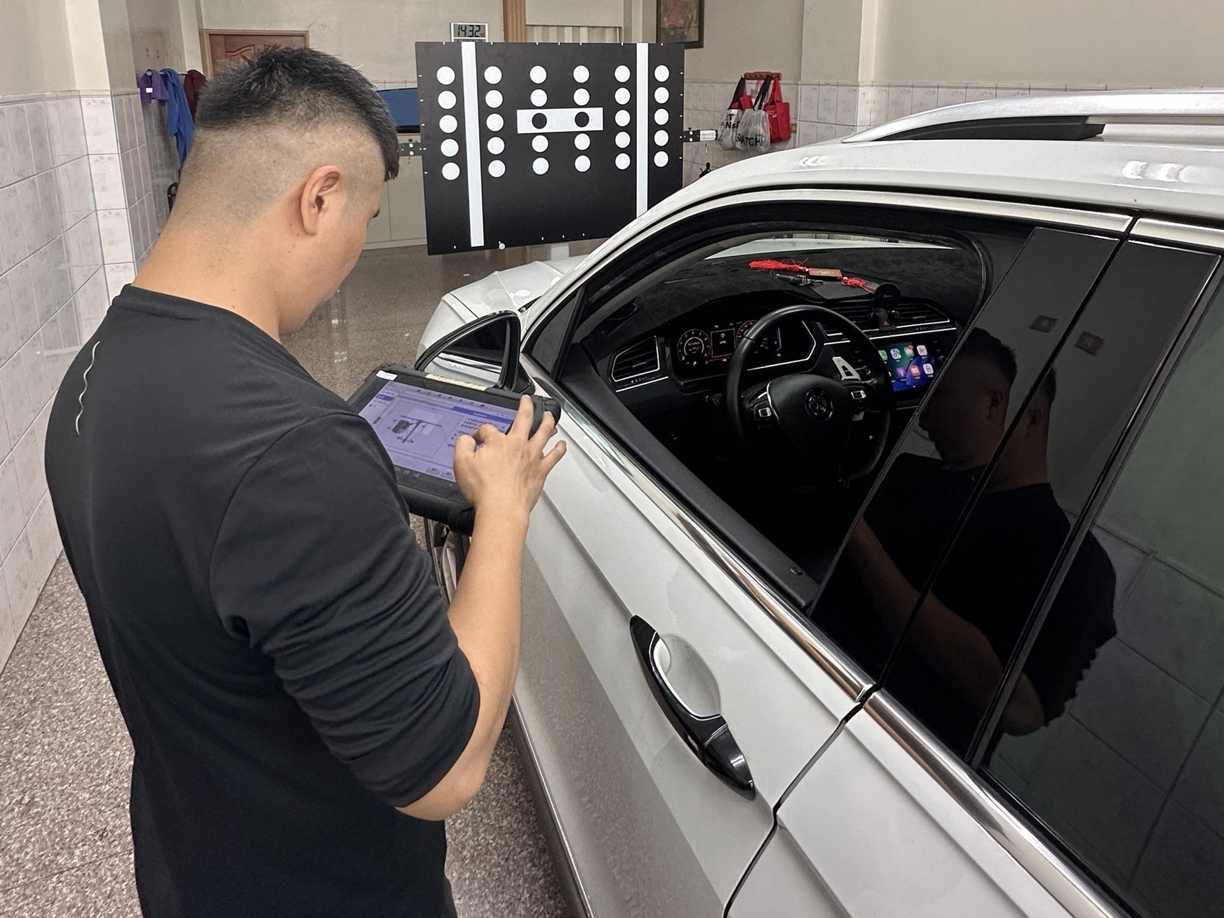 超群技師於車旁操作診斷設備,搭配前方標靶進行前識別攝影機校正作業